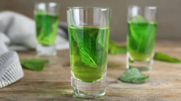 two shots of creme de menthe with mint leaves