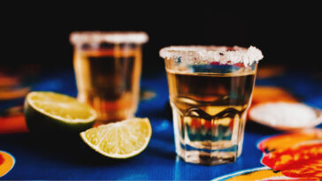 two salt rimmed tequila shots with lime slices