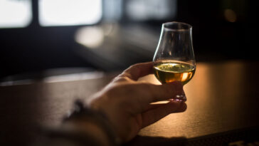 a man holding a glass of whiskey