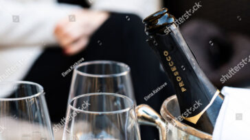 a bottle and the top of a glass of champagne