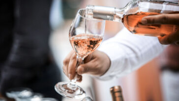 sommelier pouring a glass of rose wine