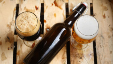 a bottle and two glasses of beer