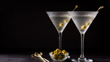 Classic Dry Martini with olives on black background.