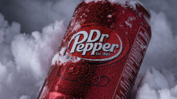 Cold can Dr Pepper with water drops in the snow in winter.