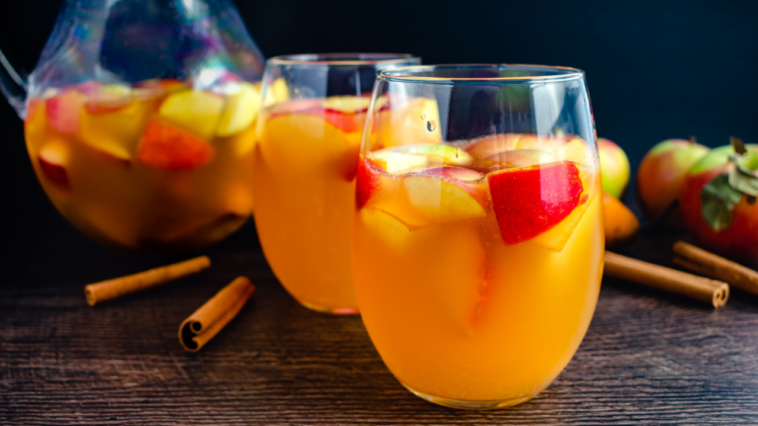 Glasses of Sangria With White Wine, Apples, Pears, and Cinnamon: Fall sangria flavored with fruit, bourbon, and maple syrup