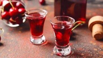 glass of liqueur with cherry heering on the table