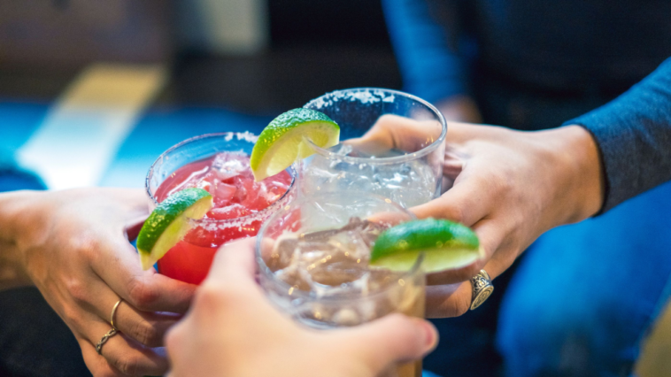 Friends toasting with margaritas and tropical drinks. Cheers!