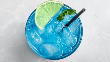 Tasty Blue Lagoon cocktail on light grey table