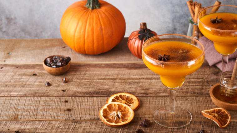 Pumpkin mocktail with cinnamon, orange juice and cocoa in glass mugs.
