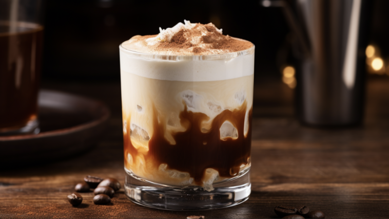 White Russian 1 image of a White Russian cocktail. The drink is served in an old-fashioned glass filled with ice cubes. It shows distinct layers, with clear vodka at the bottom, a middle layer of dark coffee liqueur, and a top layer of smooth, creamy white heavy cream. The glass is on a wooden bar counter with a cozy, dimly lit bar ambiance in the background. The cocktail is garnished with a few coffee beans on the cream layer, adding an elegant touch.