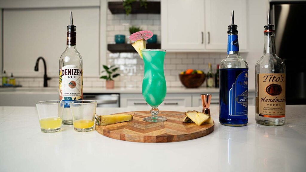 35 Beach Cocktails to Try 2 blue hawaiian cocktail and ingredients on the background