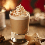 A festive holiday shot topped with whipped cream and cinnamon, served beside a star-shaped cookie on a cozy wooden table with warm candlelight ambiance.