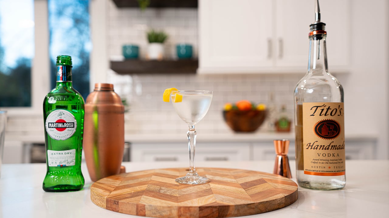 dry martini cocktail with bottles of ingredients at the background