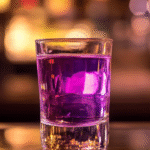 A grape vodka shot served in a clear glass, glowing under moody bar lights with soft reflections on the polished surface.